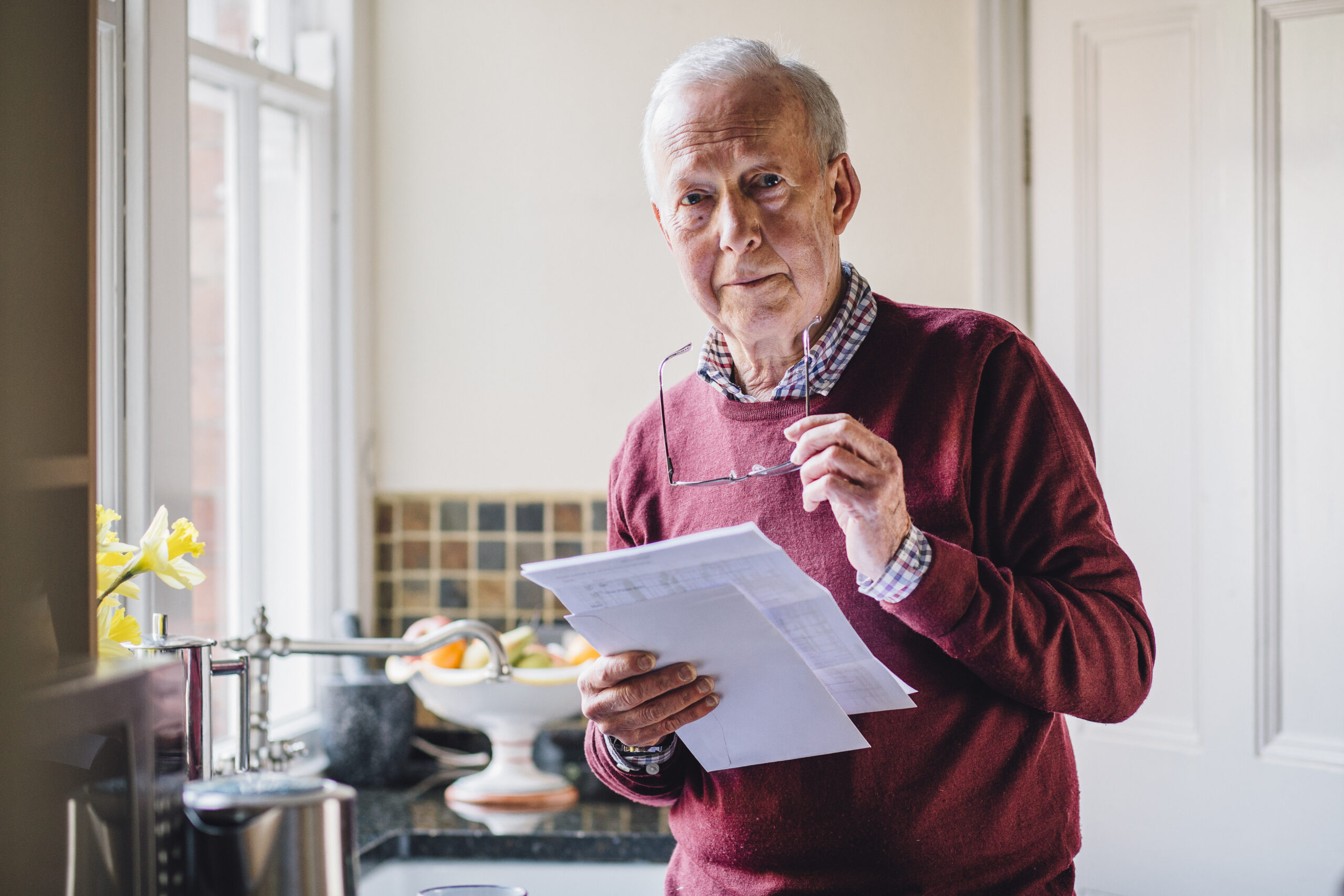 elderly man holding documents in his hand while preparing his will with The Pearce Law Group in Myrtle Beach SC.